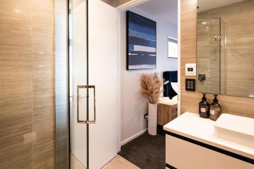 a bathroom with a sink and a glass shower at Villa Lusso - unwind in luxury and relax in the hot tub in Queenstown