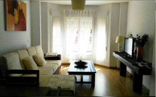 sala de estar con sofá blanco y mesa en Apartamento Cornalvo, en Trujillanos