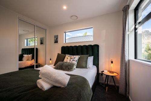 a bedroom with a large bed with a large window at Villa Lusso - unwind in luxury and relax in the hot tub in Queenstown