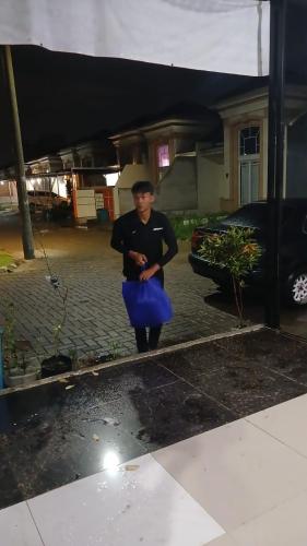 una mujer parada en un estacionamiento con una falda azul en Ifrazim home peninggilan, en Bulak