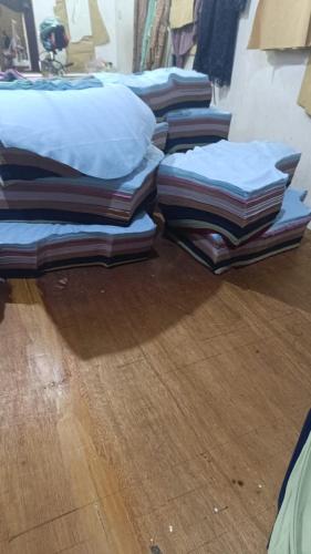 una pila de almohadas en el suelo de madera en Ifrazim home peninggilan, en Bulak
