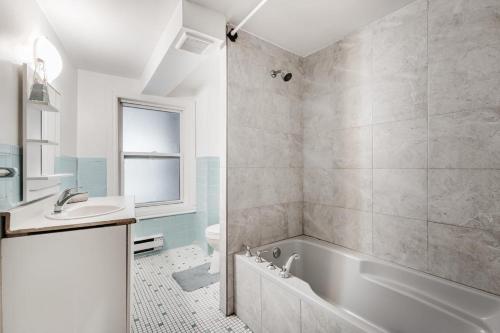 een badkamer met een bad, een toilet en een wastafel bij 2 bedroom apartment in Lasalle - 72A in Montreal