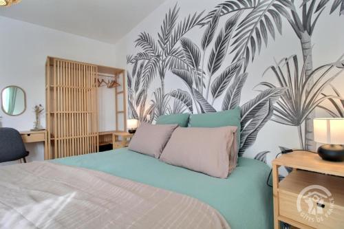 a bedroom with a bed with a mural of palm trees at La villa detente in Saint-Cast-le-Guildo