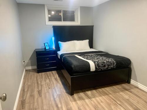 a bedroom with a bed with a black headboard at 1 room in a cozy and beautiful basement in Guelph