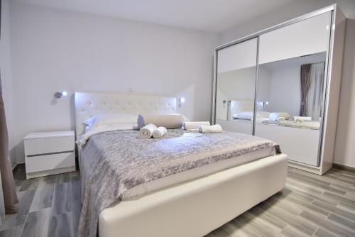 Un dormitorio con una gran cama blanca con un gran espejo. en Villa Sana, en Vir