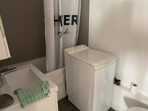ein kleines Bad mit einer Waschmaschine und einer Badewanne in der Unterkunft Appartement Cabourg, 2 pièces, 4 personnes - FR-1-465-107 in Cabourg