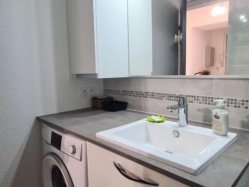 une salle de bain avec un lavabo et une machine à laver dans l'établissement Studio rénové avec piscine et garage, à 600m de la plage et 200m du port – Cap d'Agde - FR-1-249-404, au Cap d'Agde