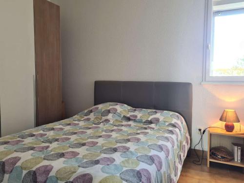 une chambre avec un lit avec une couette colorée dans l'établissement Studio rénové avec piscine et garage, à 600m de la plage et 200m du port – Cap d'Agde - FR-1-249-404, au Cap d'Agde