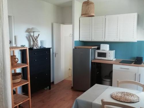 Il comprend une cuisine avec un bureau et un four micro-ondes. dans l'établissement Charmant Studio à Hyères, Proche Plage et Port, Parking et WIFI Inclus - FR-1-335-200, à Hyères