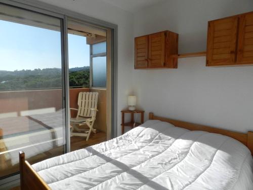 une chambre avec un lit et une vue sur un balcon dans l'établissement Appartement cosy 2 pièces avec piscine et tennis, proche plage à Bormes-les-Mimosas - FR-1-251-797, à Bormes-les-Mimosas