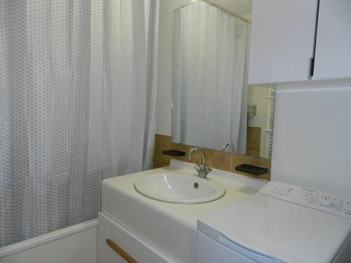 une salle de bain blanche avec un lavabo et un miroir dans l'établissement Appartement cosy 2 pièces avec piscine et tennis, proche plage à Bormes-les-Mimosas - FR-1-251-797, à Bormes-les-Mimosas