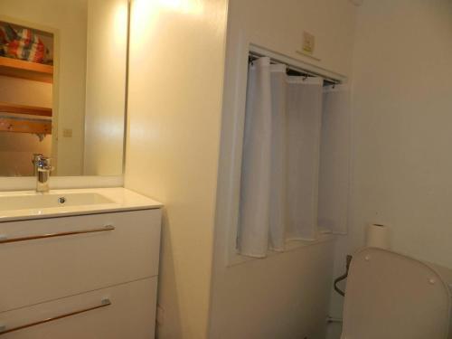 une salle de bain avec un lavabo, des toilettes et un miroir dans l'établissement Studio avec coin nuit, accès plage direct, piscine et tennis - 4 couchages - Bormes-les-Mimosas - FR-1-251-795, à Bormes-les-Mimosas