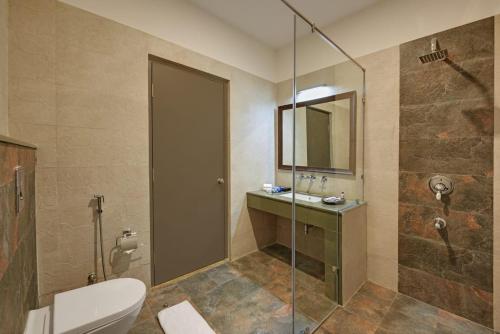 a bathroom with a shower and a toilet and a sink at The Hunting Lodge Resort Udaipur - Villas & Pool in Dabok