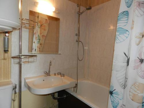 La salle de bains est pourvue d'un lavabo, d'une baignoire, d'un lavabo et d'un miroir. dans l'établissement Charmant T2 à Bormes-les-Mimosas, 4 couchages, parking, proche mer et commerces, ménage inclus - FR-1-251-803, à Bormes-les-Mimosas