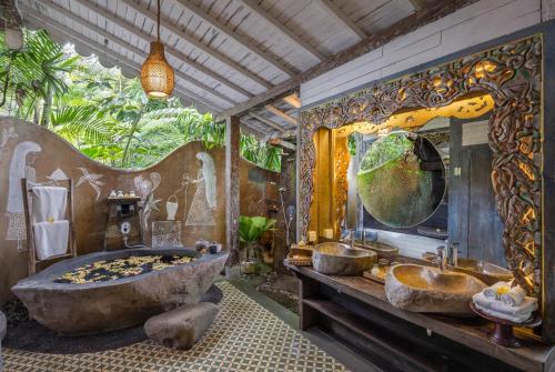 ein Badezimmer mit einer großen Badewanne und einem großen Spiegel in der Unterkunft Pramana Giri Kusuma in Payangan