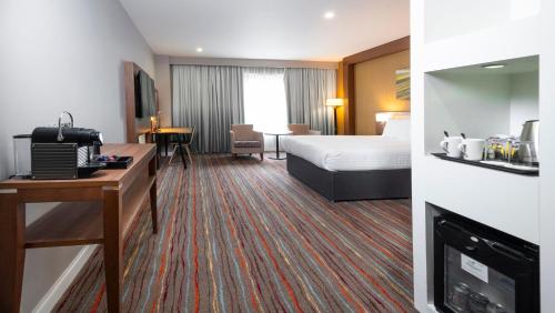a hotel room with a bed and a fireplace at Holiday Inn Derby Riverlights by IHG in Derby