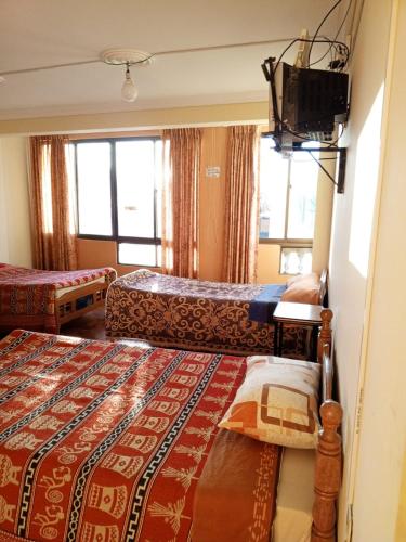 a hotel room with two beds and a television at Conquistador sucursal 1 in Copacabana