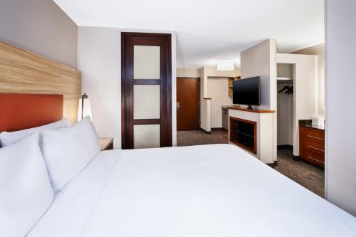 a hotel room with a bed and a flat screen tv at Candlewood Suites - Cincinnati Northeast - Mason by IHG in Mason
