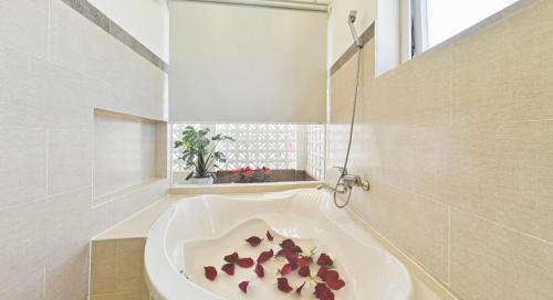 un baño con una bañera blanca con flores. en Sao Vang Hotel, en Bao Loc