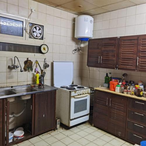 a kitchen with a sink and a stove top oven at Shared room, Roommate غرفه للمشاركه in Unayzah
