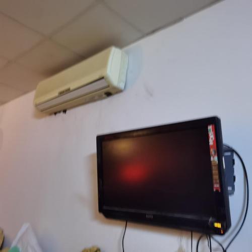 um monitor de computador com um altifalante na parede em Shared room, Roommate غرفه للمشاركه em Unayzah