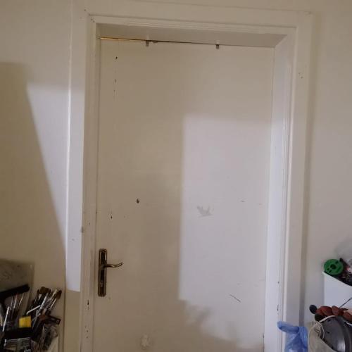 uma porta branca com uma maçaneta preta num quarto em Shared room, Roommate غرفه للمشاركه em Unayzah