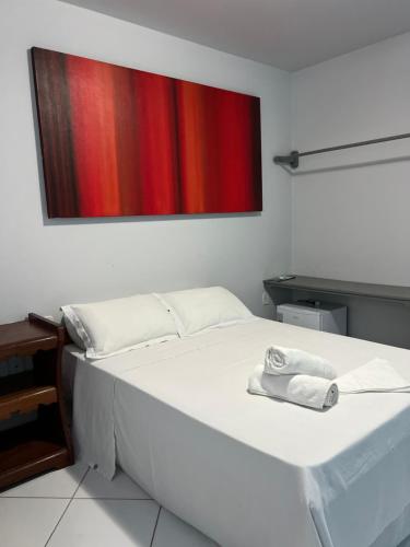 a white bed with a towel on it in a room at Pousada da Barra Prado Bahia in Prado