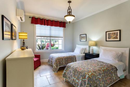 1 dormitorio con 2 camas y ventana en Knickerbocker Suite 8A 8B, en Naples
