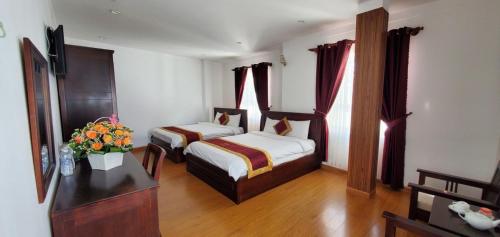 Postel nebo postele na pokoji v ubytování Tâm Dung Hotel Đà Lạt