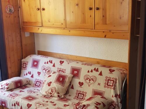 Ce petit lit se trouve dans un dortoir doté d'une armoire en bois. dans l'établissement Charmant 2 pièces avec terrasse, proche commodités et navettes, 4 pers, WiFi, parking, Châtel - FR-1-676-187, à Châtel