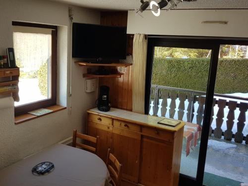 une pièce avec un bureau avec une télévision et une fenêtre dans l'établissement Charmant 2 pièces avec terrasse, proche commodités et navettes, 4 pers, WiFi, parking, Châtel - FR-1-676-187, à Châtel