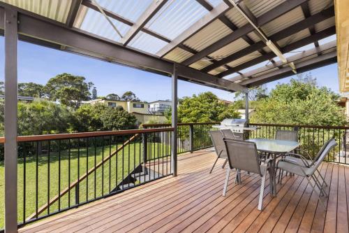 a patio with a table and chairs on a deck at Manyana Deck Life in Manyana