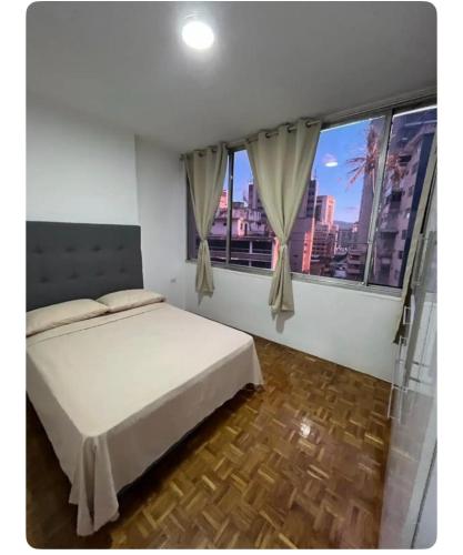 um quarto com uma cama e uma grande janela em Renewed apt in Altamira, the heart of Caracas em Caracas