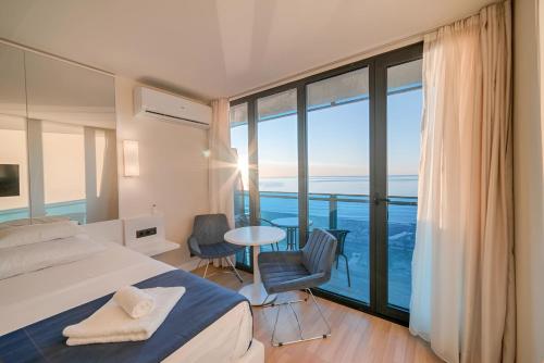 um quarto com uma cama e vista para o oceano em Orbi Hotel City Batumi em Batumi