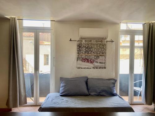 a bedroom with a bed and sliding glass doors at Duplex 5, Rue Sainte Catherine in Nîmes