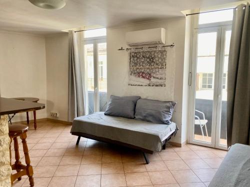 a room with a bed and a table and windows at Duplex 5, Rue Sainte Catherine in Nîmes