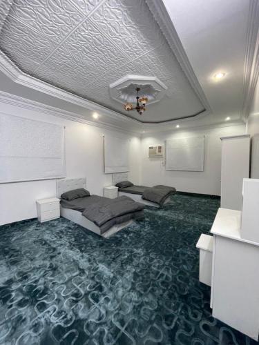 una camera con due letti e un tappeto di شقق نواف المفروشة a Al Bad‘