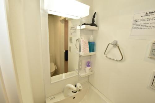baño con espejo y lavabo en Enzo iogi, en Tokio