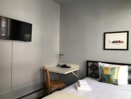 a bedroom with a bed and a desk with a television at The Urban in San Francisco