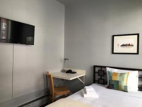 1 dormitorio con 1 cama y escritorio con TV en The Urban en San Francisco