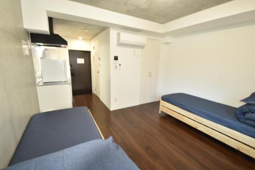 a small room with a bed and a refrigerator at Enzo iogi in Tokyo