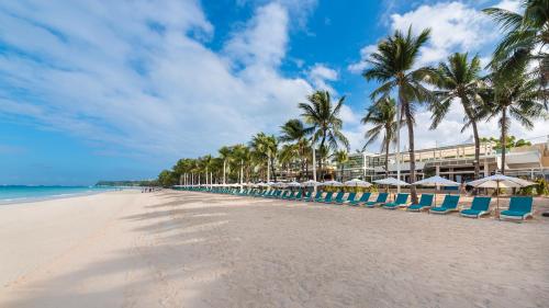 a row of beach chairs and umbrellas on a beach at Henann Regency Resort and Spa in Boracay