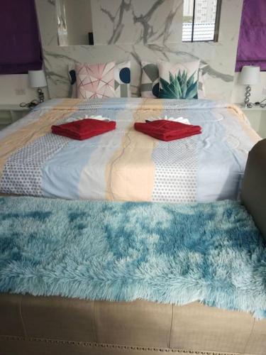 a bed with a blue blanket and pillows on it at Lee Pool Villa 39 ใกล้ทะเล ส่วนตัว in Jomtien Beach