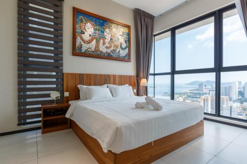 a bedroom with a large bed and a large window at Urban Suites in Jelutong
