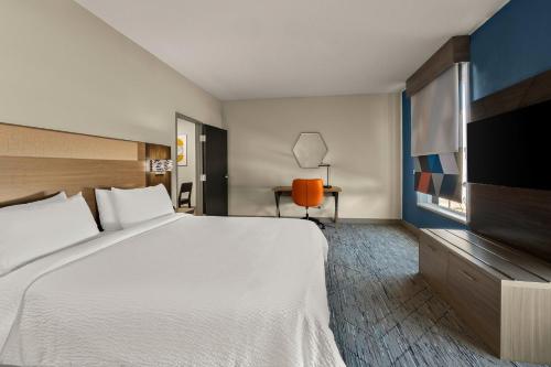 a hotel room with a large bed and a flat screen tv at Holiday Inn Express & Suites Oklahoma City NW - Quail Springs by IHG in Oklahoma City