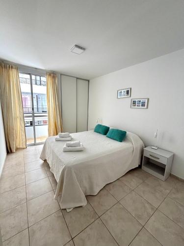 a bedroom with a large bed with blue pillows at Alojamiento confortable para tus días en Córdoba. in Córdoba