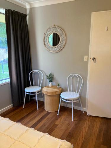 Armidale的住宿－Lennox House，一间设有两把椅子、一张桌子和一面镜子的房间