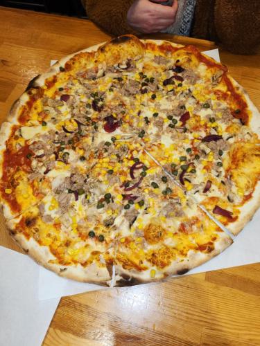 a large pizza sitting on top of a wooden table at SEDE in Mutlangen