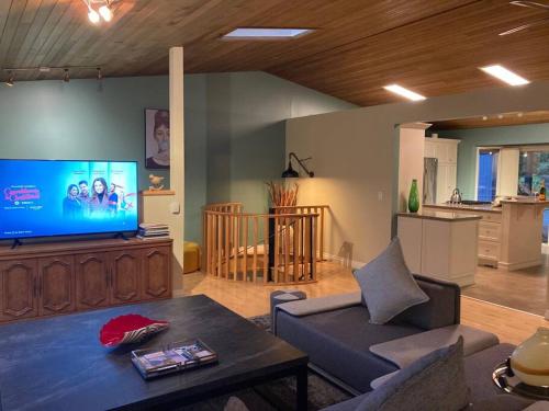 a living room with a couch and a tv at Family, Pet Friendly Sechelt Waterfront Home, Beach Access, Sleeps 14 in Sechelt