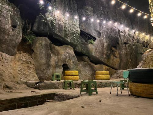 ein Zimmer mit Stühlen und Lichtern an einer Felswand in der Unterkunft Thành Đạt Hostel ( Hostel and Motobike Rental ) in Bản Tùy